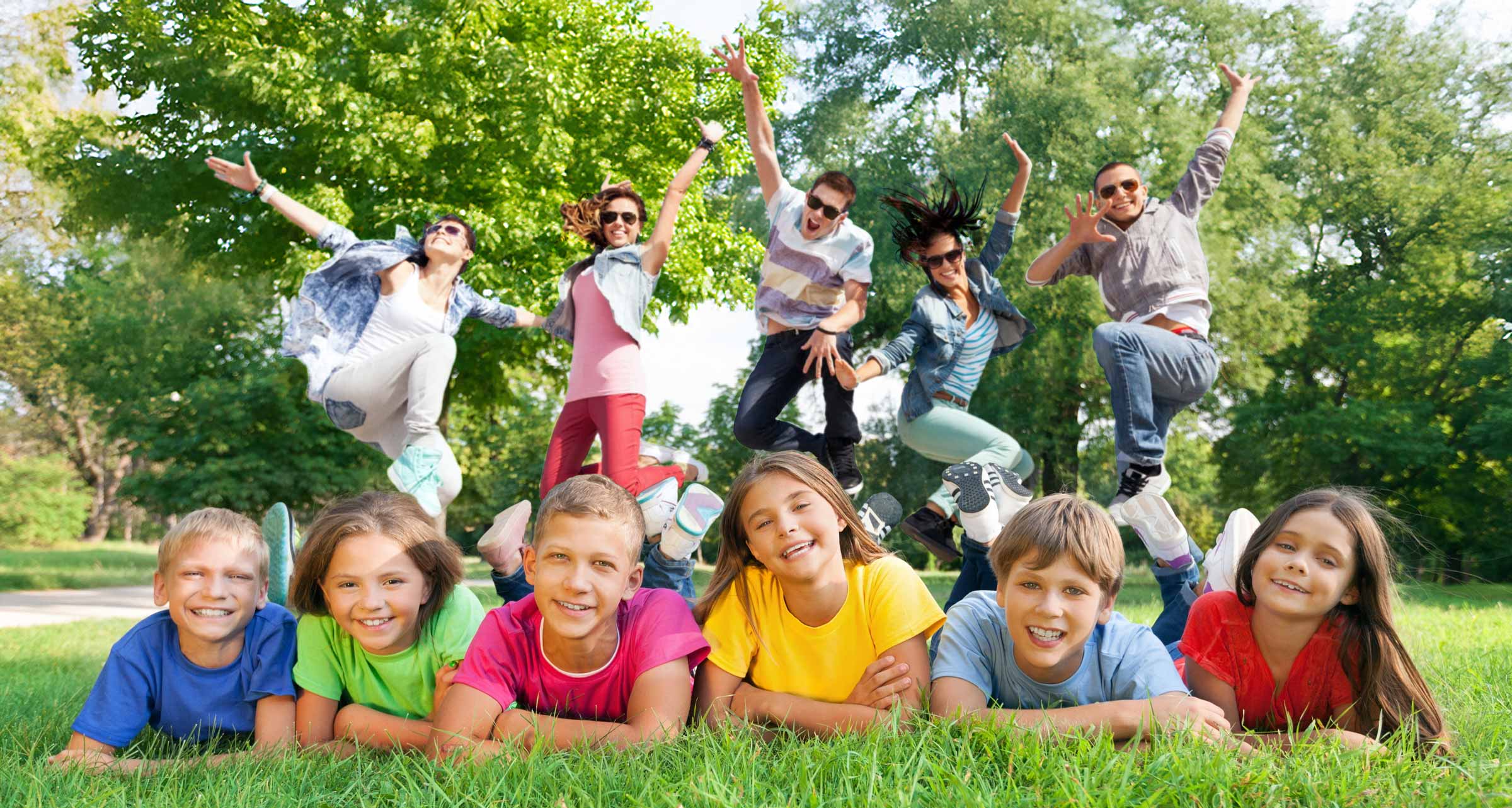 Fröhliche Kinder und Jugendliche bei Sonnenschein im Park